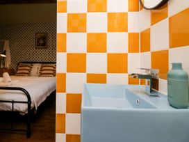 A bathroom sink with orange and white tiles at Grove House Grange-Over-Sands