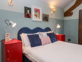 A bedroom with a blue bed and red nightstands at Grove House Grange-Over-Sands