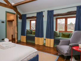 A bedroom with a bed and seating area at Grove House in Grange-Over-Sands