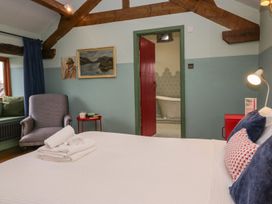 A bedroom with a bed and an armchair at Grove House in Grange-Over-Sands