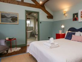 A bedroom with a bed and chair at Grove House in Grange-Over-Sands