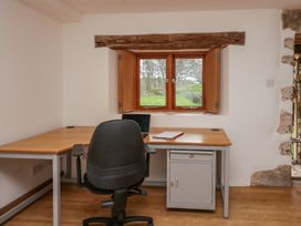 An office with a desk, chair, laptop and window at Grove House in Grange-Over-Sands