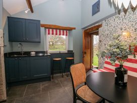 A kitchen with a sink and bar stools at Grove House in Grange-Over-Sands