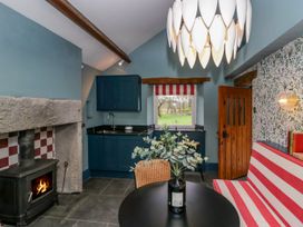 A kitchen with a stove and table at Grove House in Grange-Over-Sands