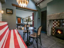 A cozy snug with seating and a fireplace at Grove House in Grange-Over-Sands