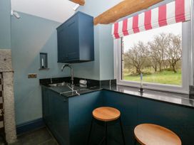 A kitchen with a sink and stools at Grove House in Grange-Over-Sands