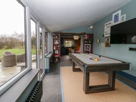 A game room with a pool table and television at Grove House in Grange-Over-Sands