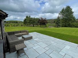 A garden with a patio and sectional sofa at Grove House in Grange-Over-Sands
