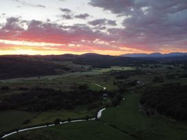 A scenic landscape with a sunset over fields and mountains at Grove House in Grange-Over-Sands