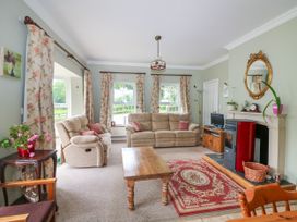 A living room with a sofa, coffee table, and television at The Lodge in Gorey, County Wexford