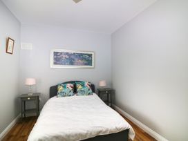 A bedroom with a bed, nightstands, and a painting at The Lodge in Gorey, County Wexford