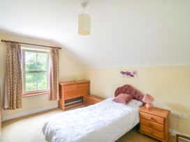 A bedroom with a bed and wooden furniture at The Lodge in Gorey, County Wexford