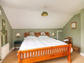 A bedroom with a bed, lamp, nightstand and mirror at The Lodge in Gorey, County Wexford