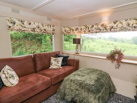 A living room with a sofa and lamp at Gwybedog in Llanwrda