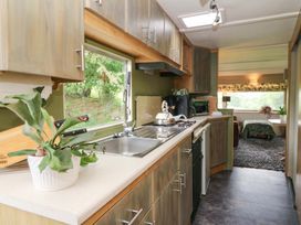 A kitchen featuring a sink, stove and cabinets at Gwybedog in Llanwrda