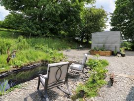 A garden with chairs and a pond at Gwybedog in Llanwrda