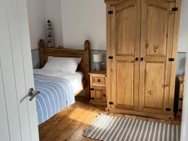 A bedroom with a bed, wardrobe, and nightstand at 21 Station Hill
