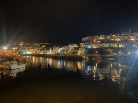 A harbor with boats and illuminated buildings at night at 21 Station Hill