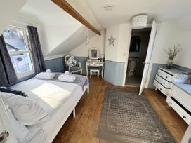 A bedroom with a bed and dresser at Still Waters in Brixham