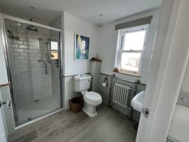 A bathroom with a shower, toilet, and sink at Still Waters in Brixham
