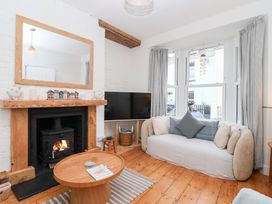 A living room with a sofa and fireplace at Still Waters in Brixham