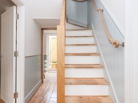 A hallway with stairs and a door at Still Waters in Brixham