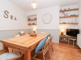 A dining room with a wooden table and chairs at Still Waters in Brixham