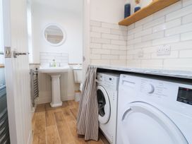 A laundry room featuring a washing machine and sink at Still Waters in Brixham
