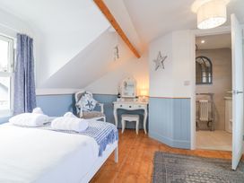 A bedroom with a bed and vanity at Still Waters in Brixham