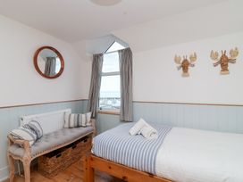 A bedroom with a bed and a sofa at Still Waters in Brixham