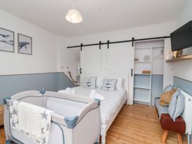 A bedroom with a bed and crib at Still Waters in Brixham