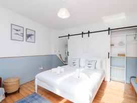 A bedroom with a bed and wall art at Still Waters in Brixham