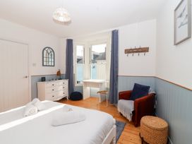 A bedroom with a bed, dresser, and desk at Still Waters in Brixham