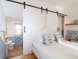 A bedroom with a sliding door and bed at Still Waters Brixham