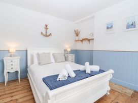 A bedroom with a bed and nightstands at Still Waters in Brixham