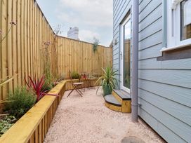 A garden area with an outdoor table and chair at Still Waters in Brixham