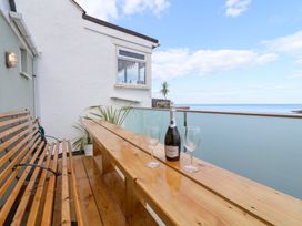 A balcony with a bottle of prosecco and glasses at Still Waters in Brixham