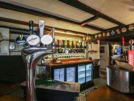 A bar with beer taps and bottle displays at Penny Farthing Inn Aston Crews near Ross-On-Wye