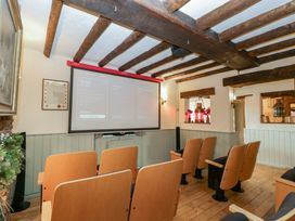 A cinema room with chairs facing a projector screen at Penny Farthing Inn Aston Crews near Ross-On-Wye