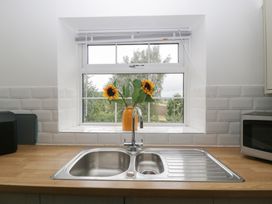 A kitchen with a sink and sunflowers on the countertop at Penny Farthing Inn Aston Crews near Ross-On-Wye