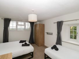 A bedroom with two beds and a wardrobe at Penny Farthing Inn Aston Crews near Ross-On-Wye