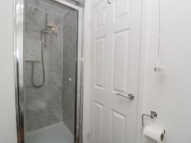 A shower with a door and towel holder at Penny Farthing Inn Aston Crews near Ross-On-Wye