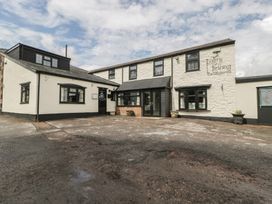 An outdoor view of the Penny Farthing Inn restaurant with entrances and parking area in Aston Crews near Ross-On-Wye