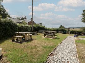 An outdoor area with picnic tables and a playground structure at Penny Farthing Inn Aston Crews near Ross-On-Wye
