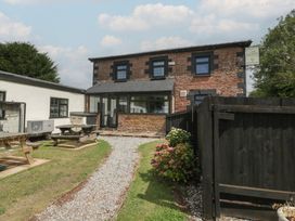 A building with a pathway and picnic tables in the outdoor area at Penny Farthing Inn Aston Crews near Ross-On-Wye
