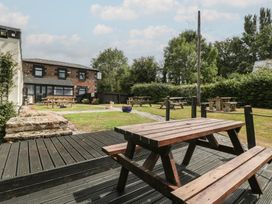 An outdoor seating area with tables and grass at Penny Farthing Inn Aston Crews near Ross-On-Wye
