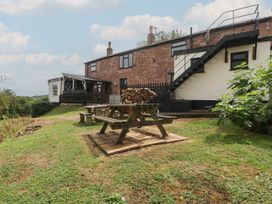 An outdoor area with a picnic table and benches at Penny Farthing Inn Aston Crews near Ross-On-Wye