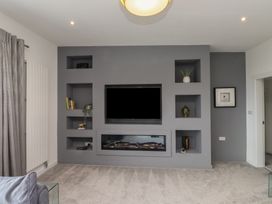 A living room with a television and shelves at 70 Deganwy Road in Deganwy