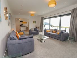 A living room with sofas and large windows at 70 Deganwy Road in Deganwy