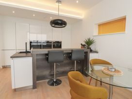 A kitchen with a dining table and bar stools at 70 Deganwy Road in Deganwy